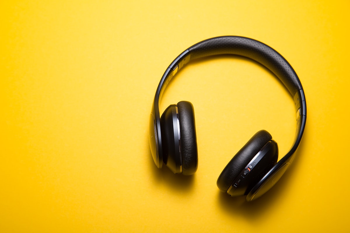 Black over-ear headphones on a yellow background